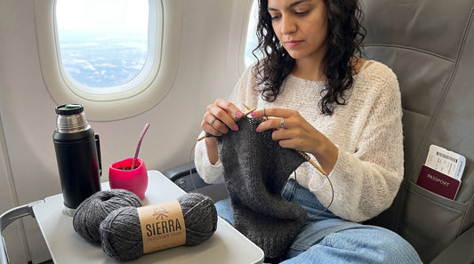 Woman knitting with Cloudtouch Baby Alpaca Pima Cotton Blend yarn on an airplane using bamboo circular needles TSA approved