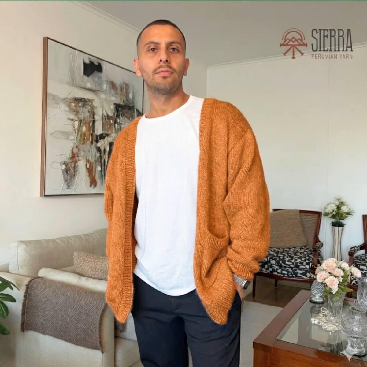 Man wearing Nomad Cardigan Knitting Kit in Orange Baby Alpaca Pima Cotton Cloudtouch Blend