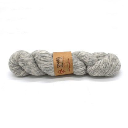 Gray skein of yarn with a brown label on a white background