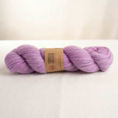Andean Solid Lavender skein of Cloudtouch Baby Alpaca Pima Cotton Blend for knitting kits by Sierra Yarns, with a kraft paper label reading “Love is all we knit.”