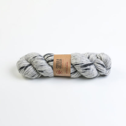 Grey and charcoal skein of yarn with a Sierra label on a white background